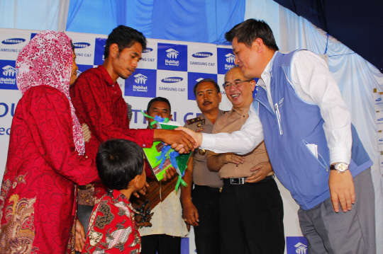 삼성물산이 국내 건설사로서는 처음으로 인도네시아에 삼성물산의 이름을 딴 마을을 완공했다. 한정진 인도네시아 지점장(맨 오른쪽)이 입주민에게 주택 현관 열쇠를 건네고 있다. 사진= 삼성물산 제공